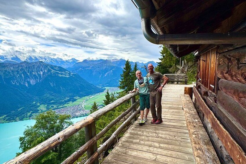 Un pontile in legno con vista su un paesaggio montuoso, un lago e una cittadina sottostante. 2