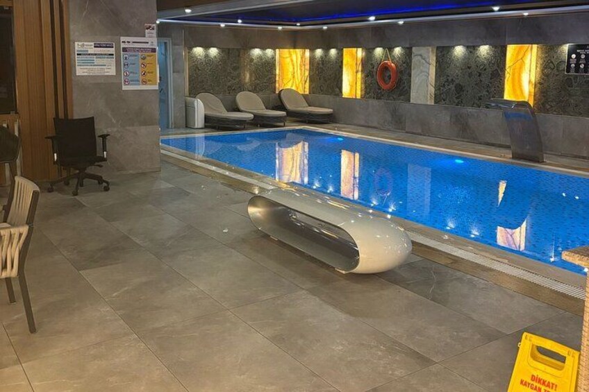 Una piscina con sillas de descanso, un flotador salvavidas y un letrero de precaución amarillo. 5