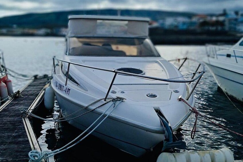 A white boat docked at a pier with a clear sky in the background. 1