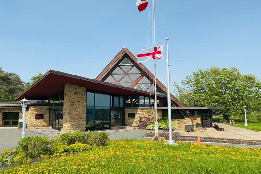 A modern building with a glass facade, a stone base, and a triangular roof. 2