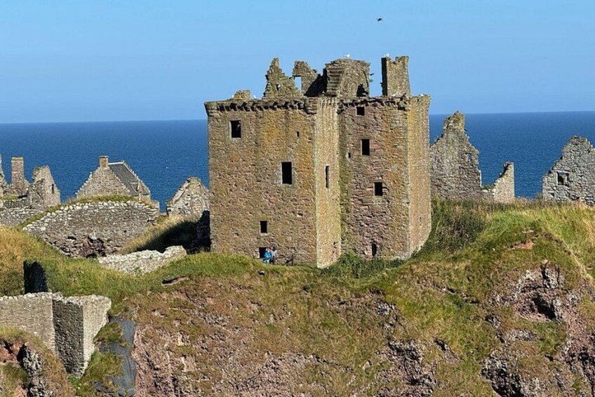 A ruined castle with a clear view of the sea in the background. 3