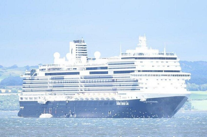 A large cruise ship sailing on the water with a mountainous landscape in the background. 2