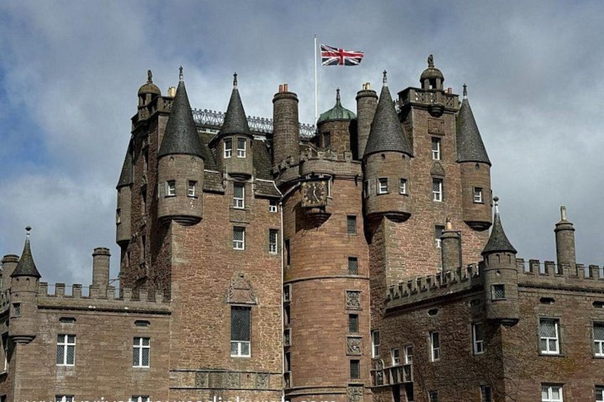 A large, historic castle with multiple towers and a flag. 2