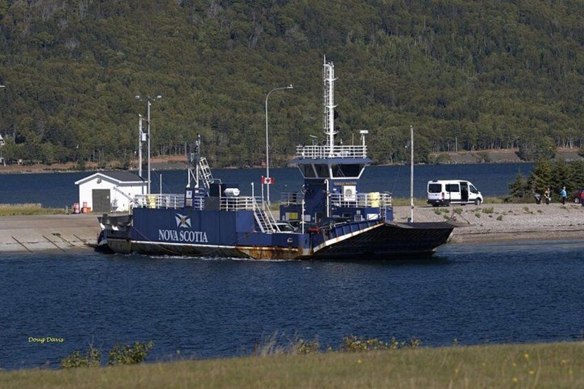 Un ferry llamado 'Nova Scotia' atracado en un muelle con una orilla boscosa al fondo. 4