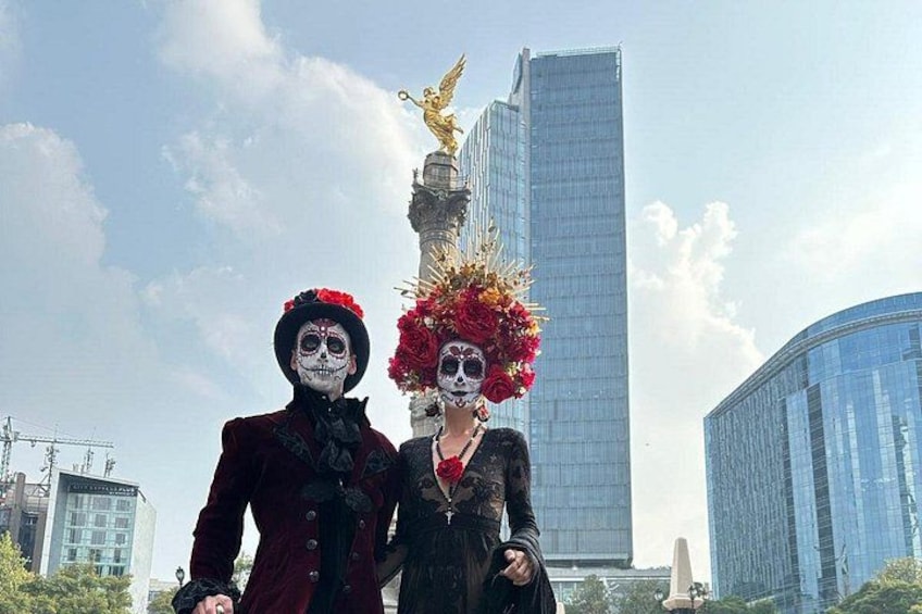 Two people in elaborate costumes with a modern cityscape in the background. 1