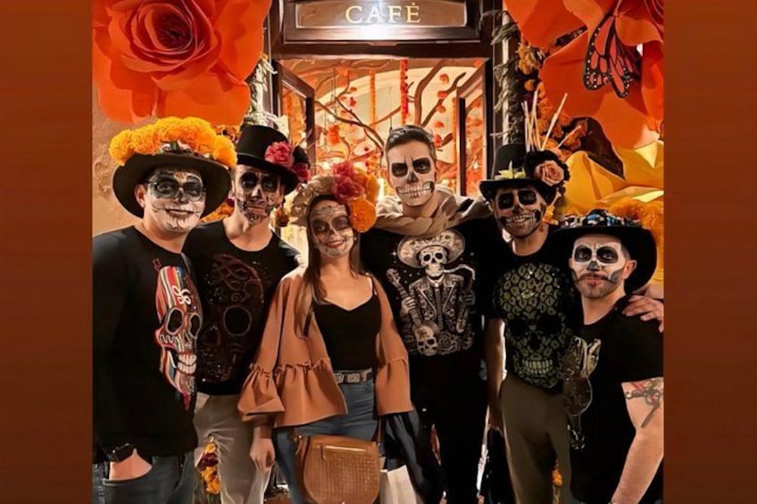 A group of people in a café with a festive atmosphere, featuring orange and yellow decorations. 2