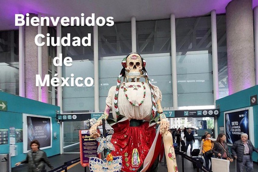 A skeleton figure in traditional attire, a sign reading 'Bienvenidos Ciudad de México,' and a modern building with glass windows. 5
