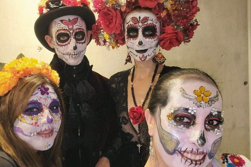 Personas con pintura facial y adornos de flores en la cabeza. 2