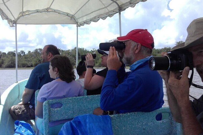 Personas en un barco, algunas fotografiando con cámaras. 1