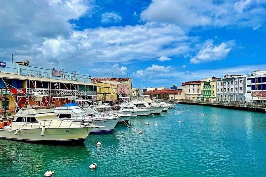 A marina with several boats docked, colorful buildings, and a clear blue sky. 2