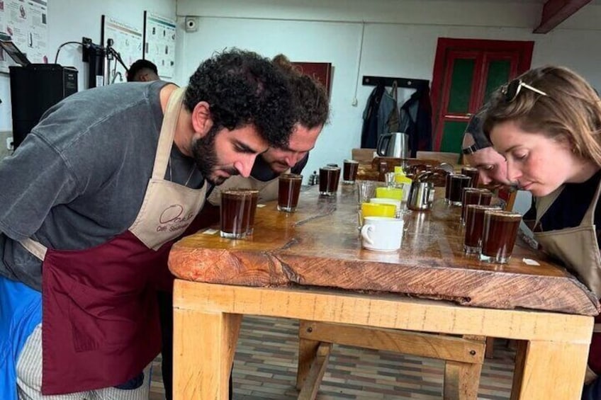 Zwei Personen probieren Getränke an einem Holztisch, mit Gläsern und einem Brotlaib. 5