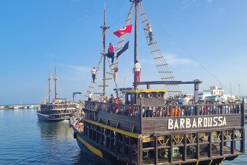 A wooden pier with a ship named 'BARBAROSSA' docked at a marina. 4