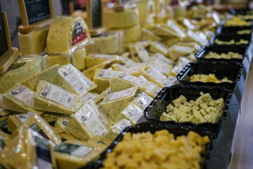 A variety of cheeses displayed in trays and wrapped in plastic. 4