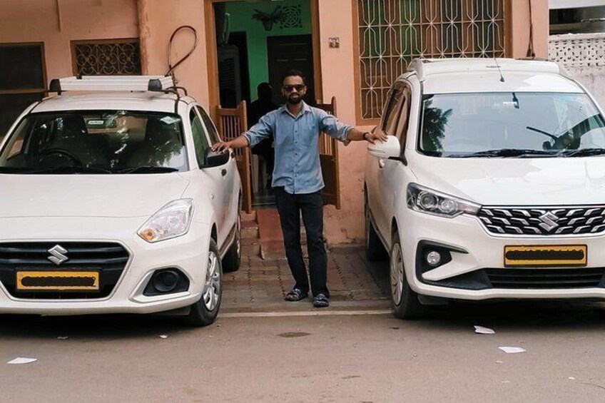 Una persona parada entre dos coches blancos estacionados en una calle. 3