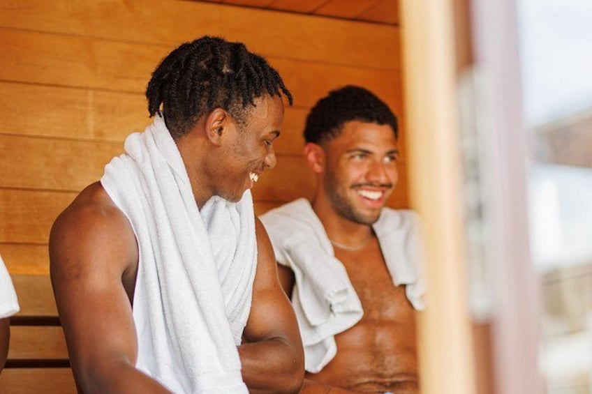 Dos personas en una sauna de paredes de madera. 2