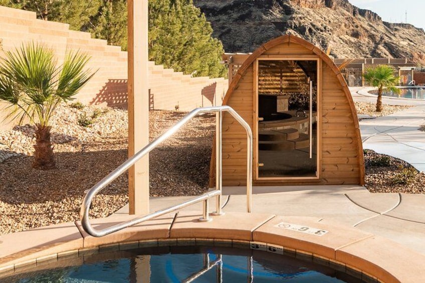 A swimming pool with a wooden structure, a palm tree, and a mountainous background. 2