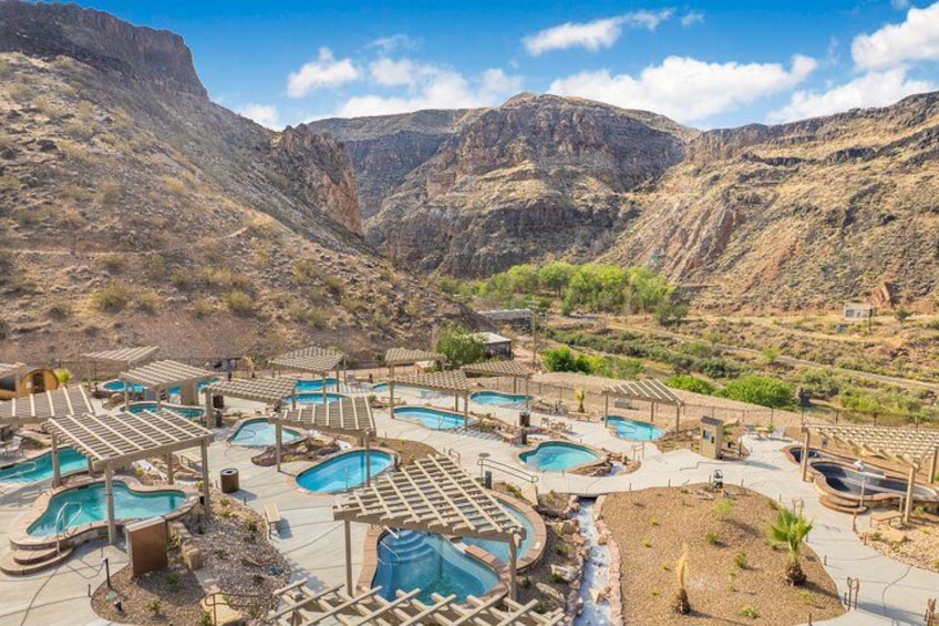 A resort with multiple swimming pools set against a mountainous backdrop. 4