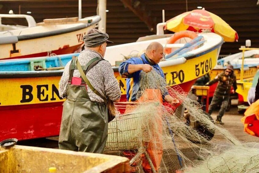 En mand håndterer fiskegrene tæt ved en båd med nummer 5760. 2
