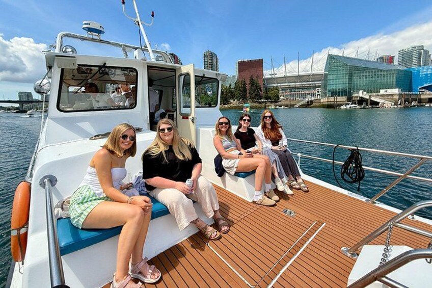 Een groep mensen op een boot, met een stadsachtergrond op de achtergrond. 4