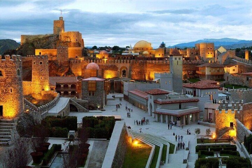 A historic walled city with ancient architecture, including towers and domes, during twilight. 1