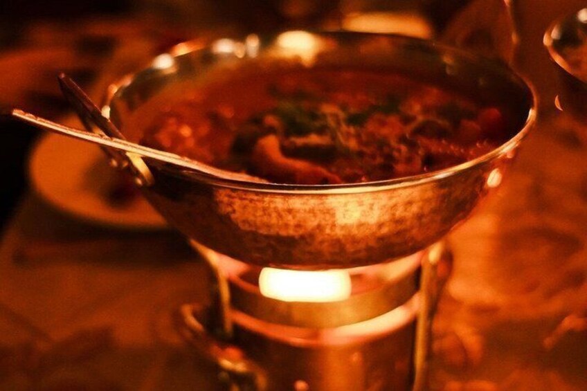 A metal bowl with a handle, placed on a stove with a flame underneath. 4