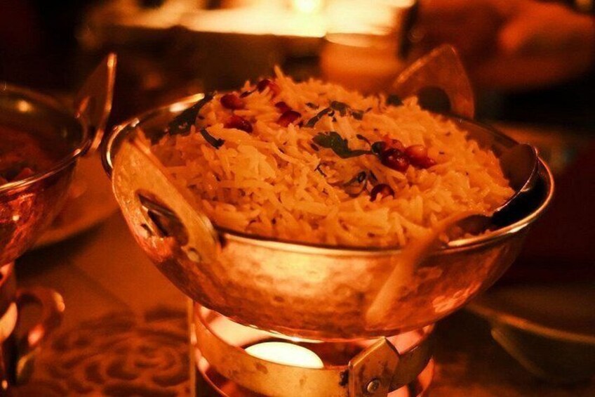A bowl of rice with herbs and spices, served on a metal stand. 5