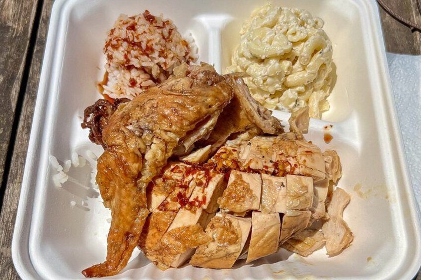 A takeout container with a chicken leg, rice, and macaroni salad. 3