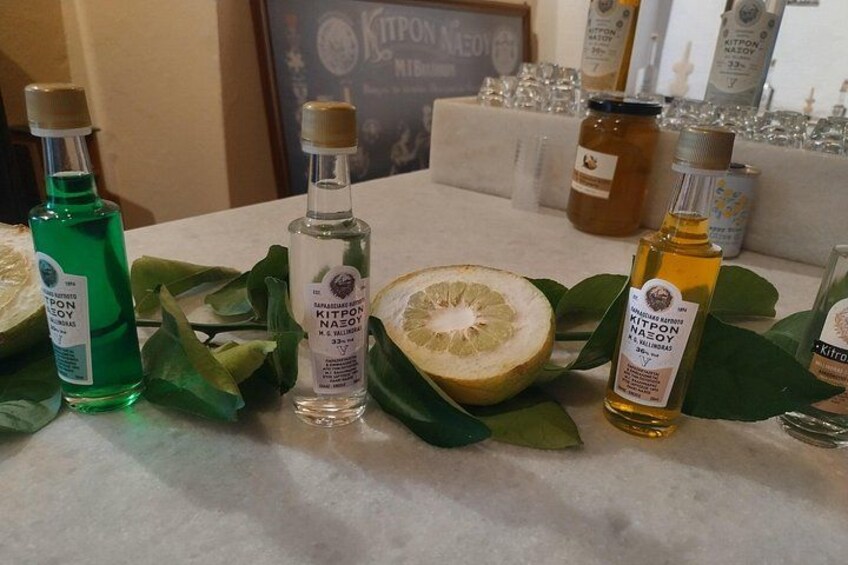 Botellas de Kitpon Naoyō sobre una mesa con hojas verdes y media fruta cítrica. 5