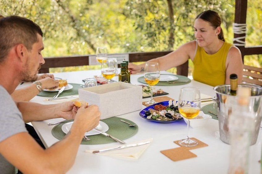 Una mesa de comedor con platos, vasos y una botella. 2