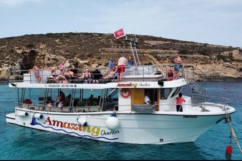 A boat named 'Amazing Charters' with people on board, sailing in clear waters. 3