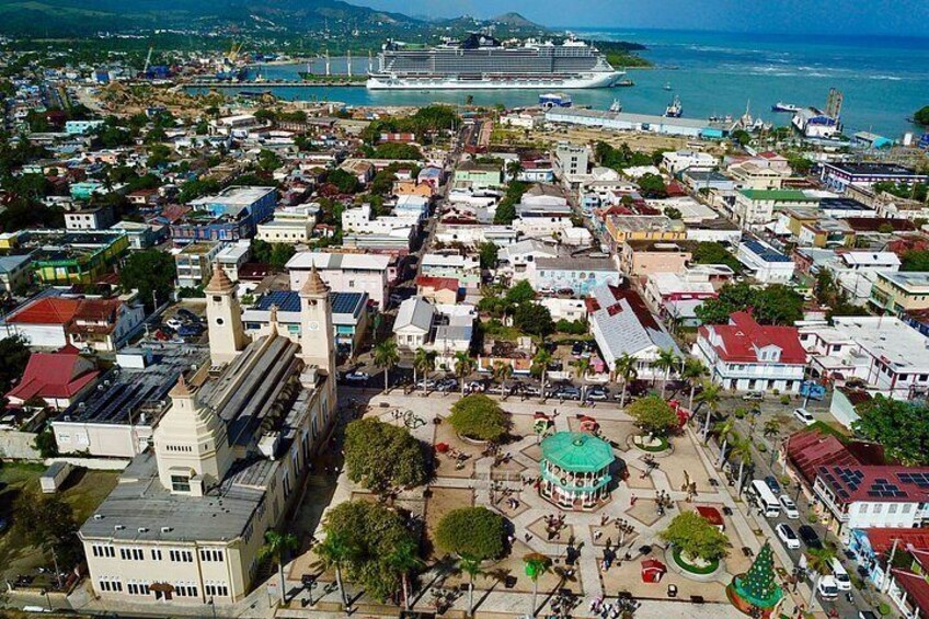 Une ville côtière qui se distingue par son église imposante, la présence d’un grand navire de croisière et un port animé. 3