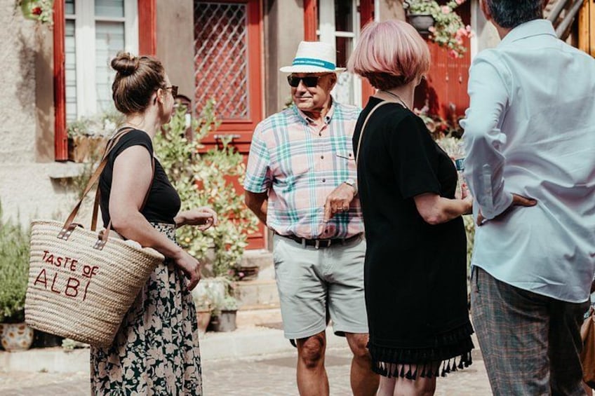 A group of people standing outdoors, engaged in conversation. 5