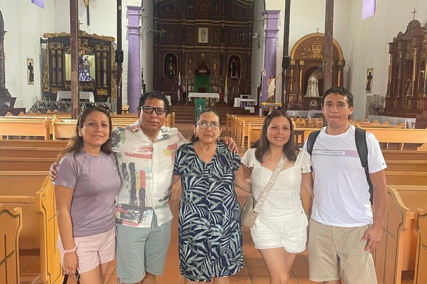 A group of people inside a church with ornate architecture and pews. 2