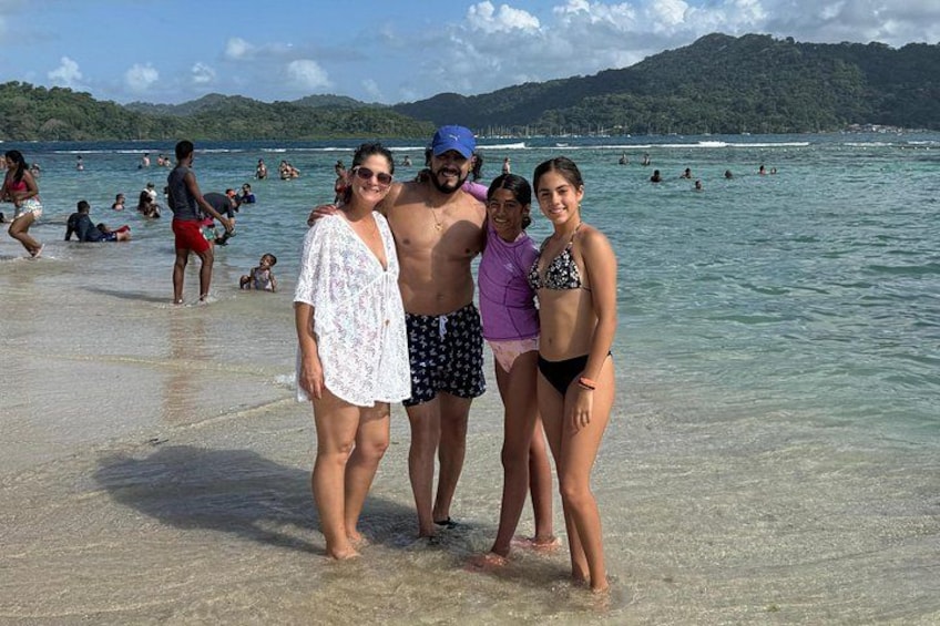 A beach with people swimming and standing in the water. 2