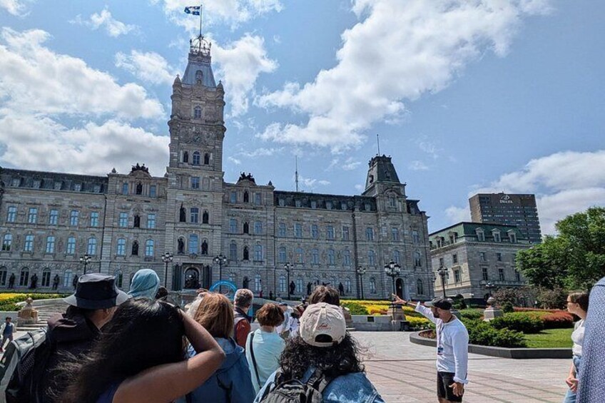 A historic building with a tall tower, surrounded by a crowd of people. 2