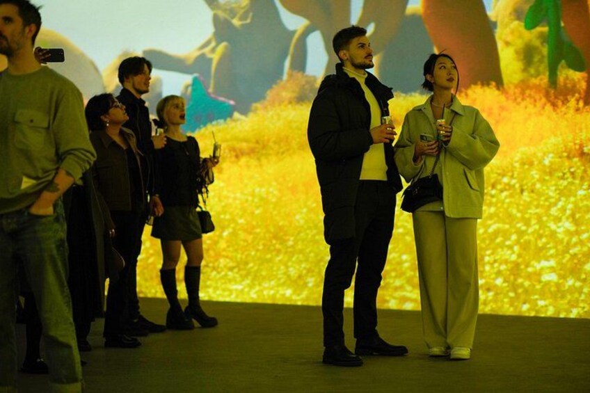 A group of people standing on a stage with a large screen displaying a nature scene in the background. 2