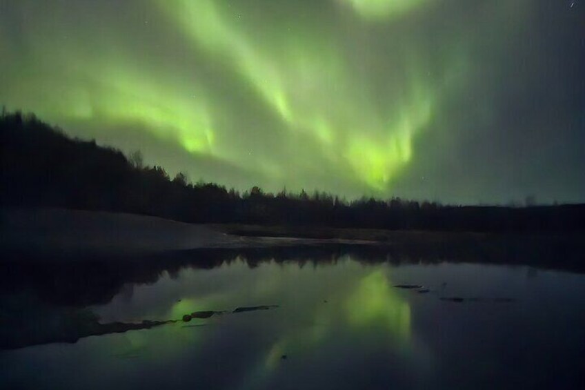 A calm lake reflecting the northern lights. 4