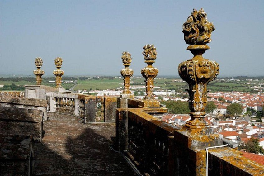 A historic stone bridge with ornate golden balustrades overlooking a town. 4