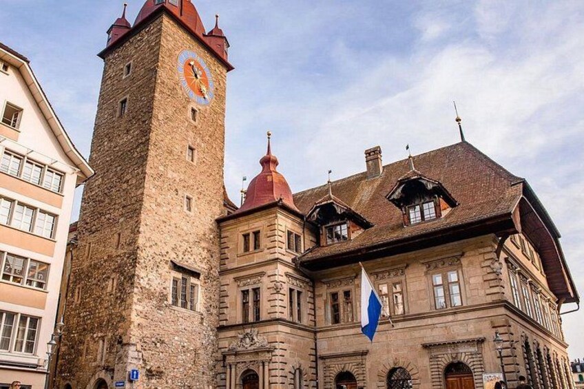 A historic building with a clock tower and a flag. 5