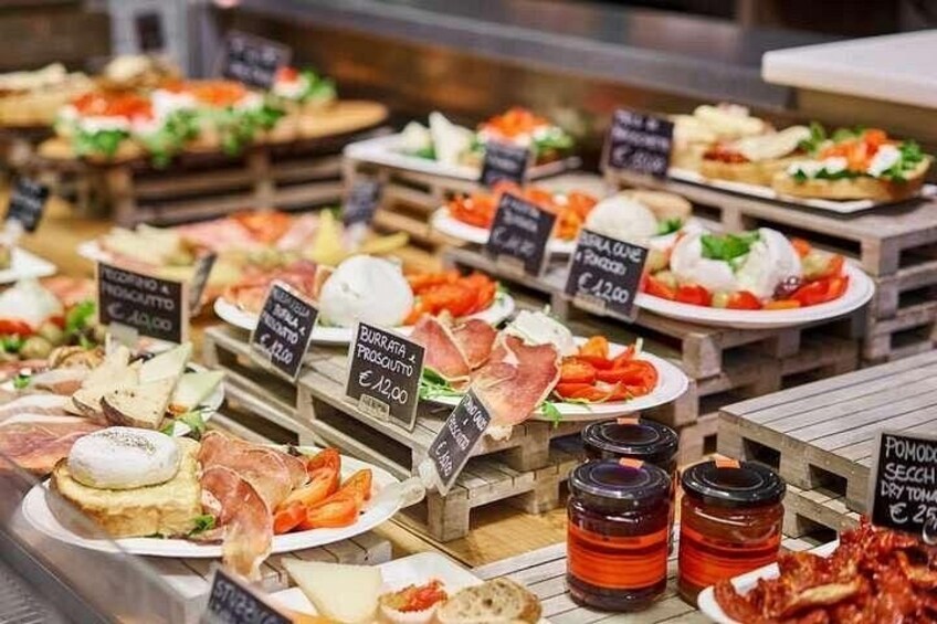An assortment of food items displayed on wooden tables with price tags. 3