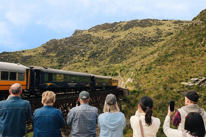 Un train circule sur les voies ferrées, et des personnes l'observent. 2