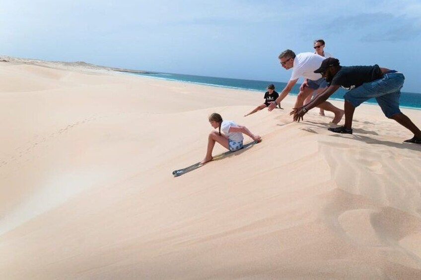 A group of people on a sandy beach with a clear sky. 5