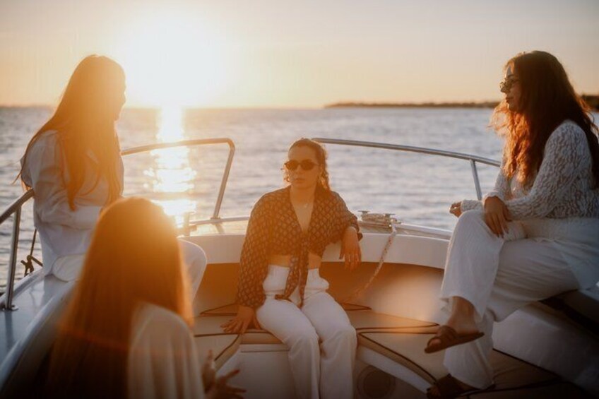 A sunset over water with people on a boat. 5