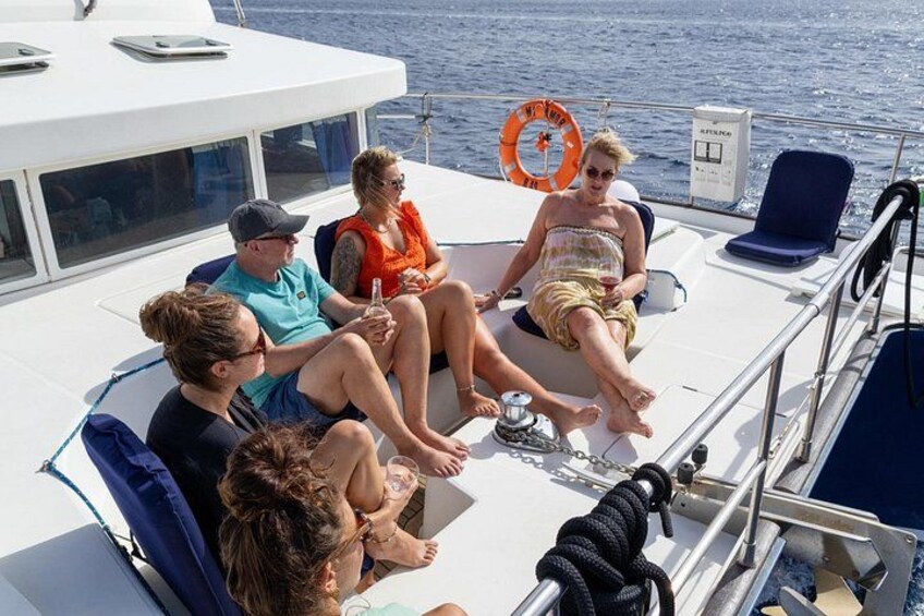 A group of people on a boat with life jackets and a rope. 2