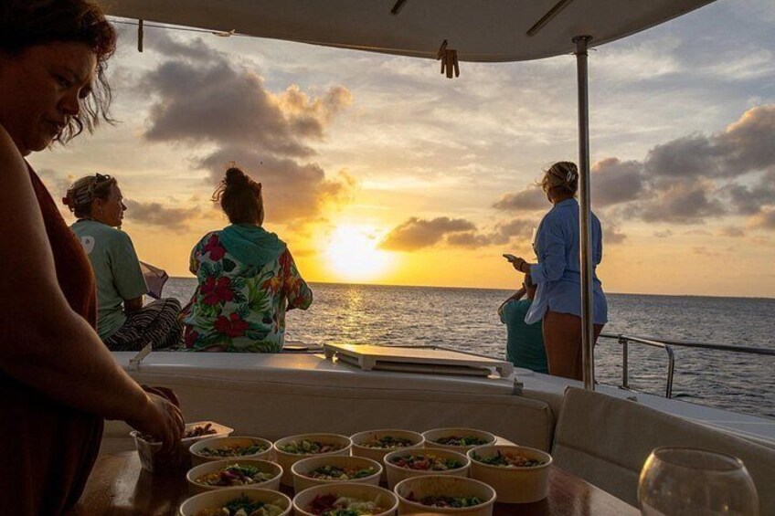 A sunset over the ocean with people on a boat. 1