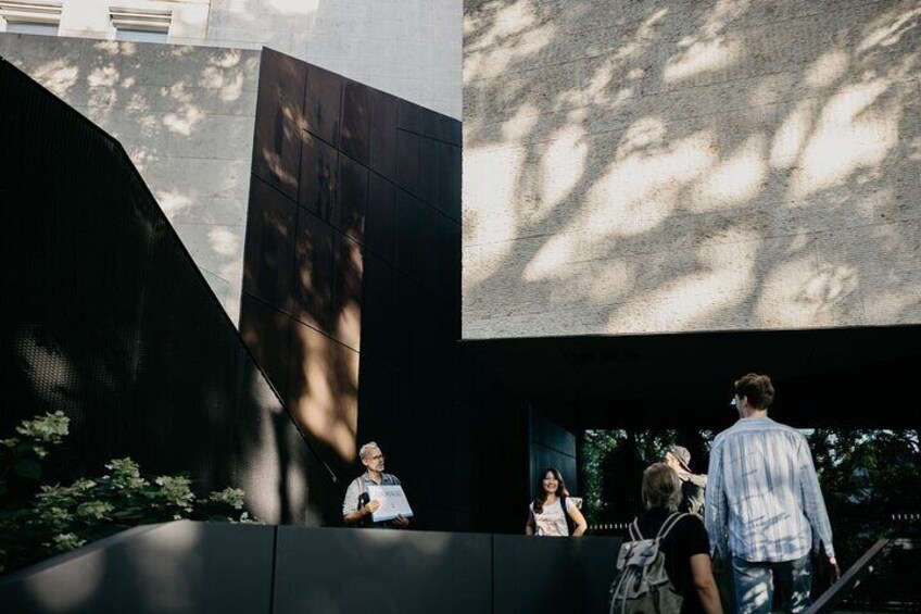 A modern building with a large reflective surface and a staircase leading up to it. 4