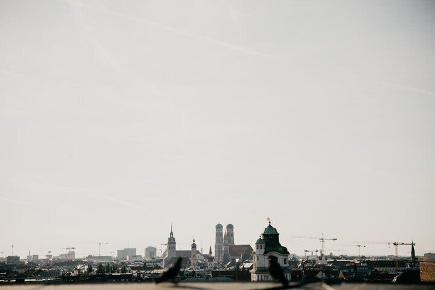 A city skyline with prominent buildings and construction cranes. 2