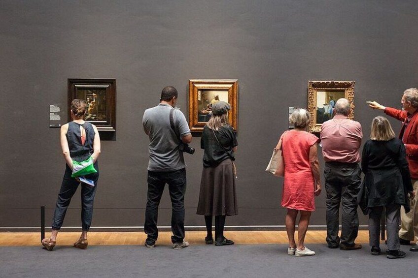 Människor som betraktar målningar i ett konstgalleri. 3