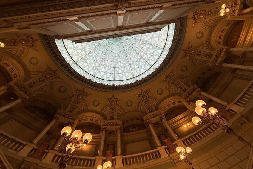 A grand interior with a large, ornate dome ceiling and multiple chandeliers. 3