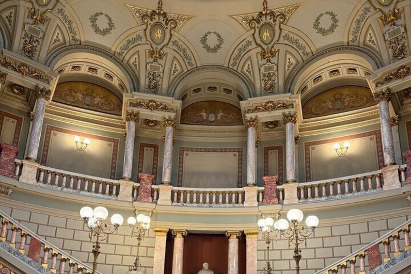 A grand theater with ornate decorations, a balcony, and a staircase. 5
